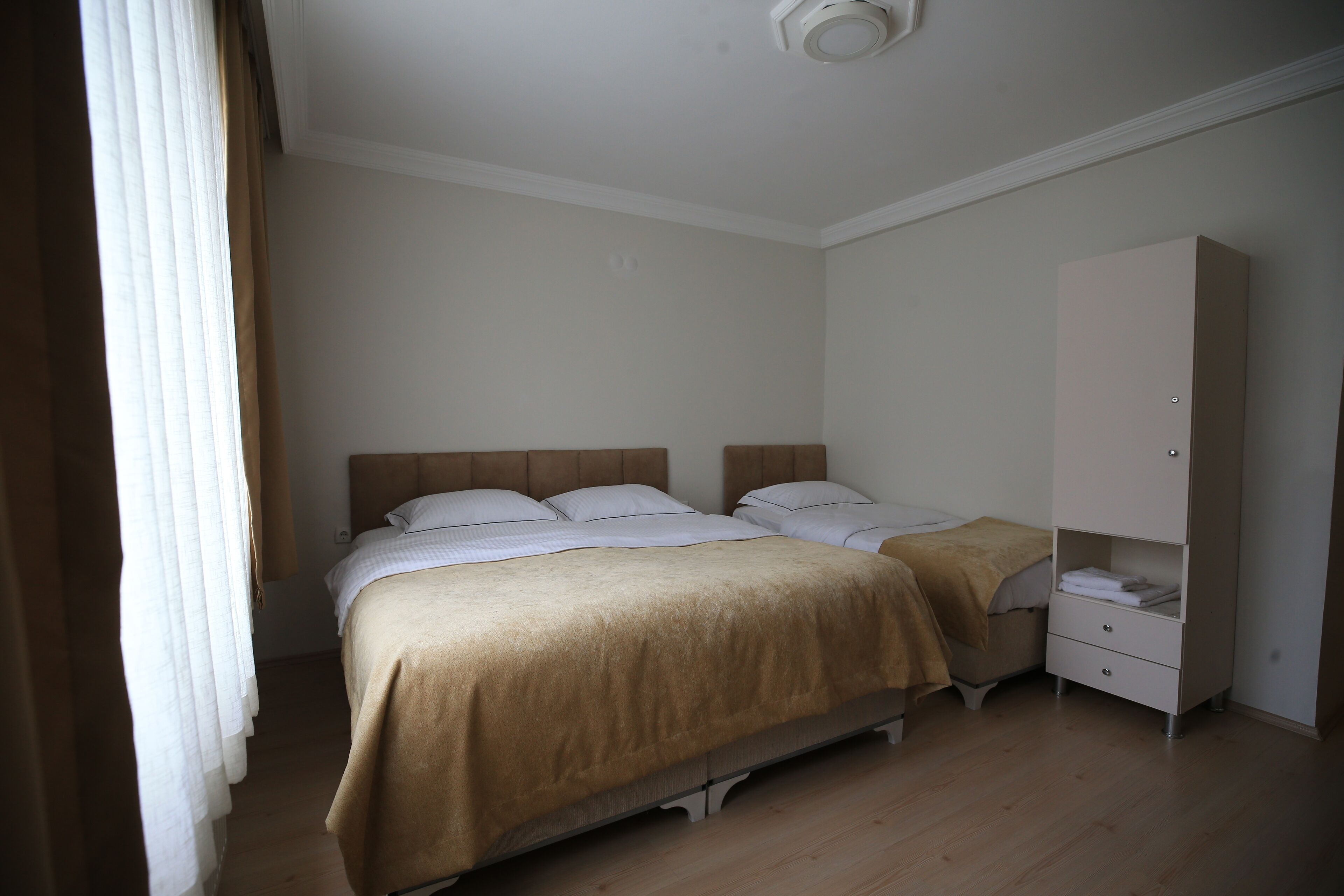 A bedroom with a bed, nightstands, and a wardrobe.
