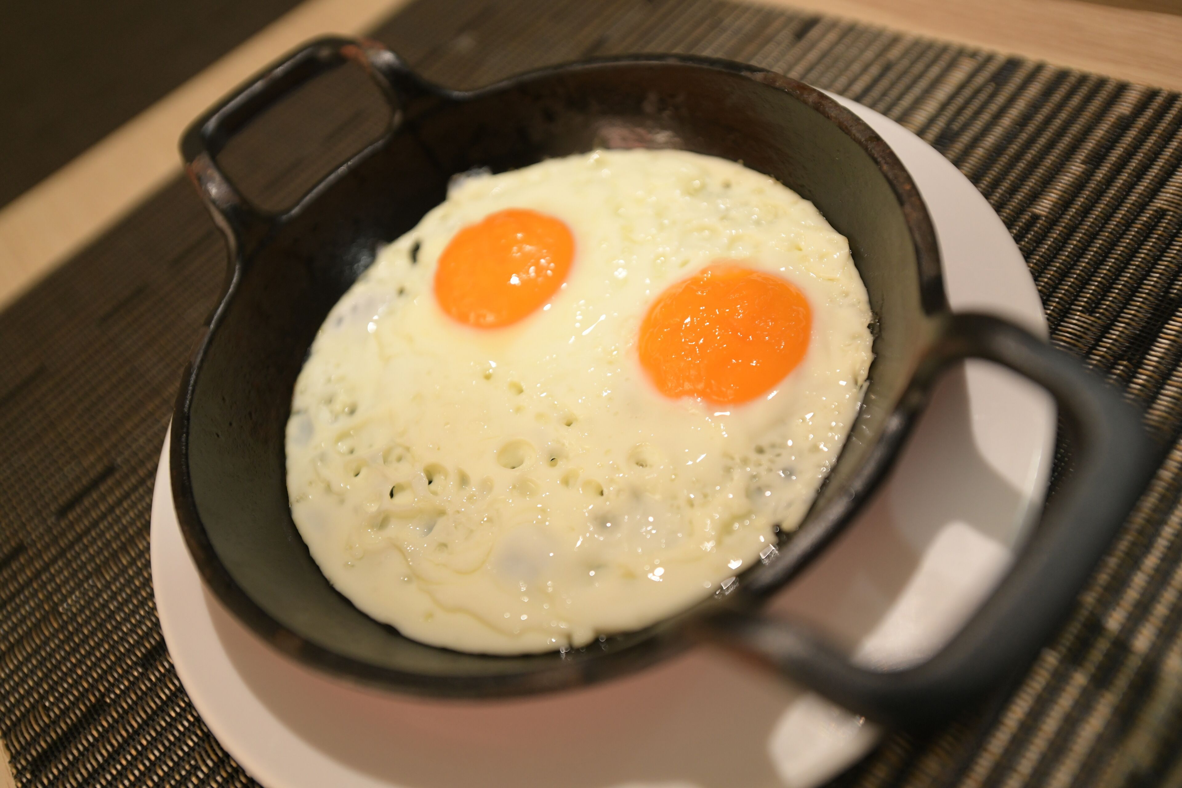 Una sartén con dos huevos estrellados en un plato.