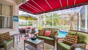 A covered patio area with wicker furniture, a pool, and a view of the outdoors. - "southern Charm" 4 Bed & 2 Bath Private Pool Home 4 Bedroom Villa by RedAwning (Davenport)