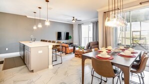 Eine moderne Küche mit Essbereich, Deckenventilator und großem Fenster.