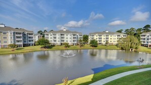 A multi-story residential building with a central courtyard featuring a fountain. - 4827 Magnolia Lake Drive, #302 3 Bedroom Condo by RedAwning (Myrtle Beach)