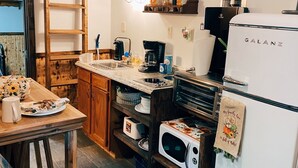 Eine Küche mit Holzausstattung, einem Galanz-Kühlschrank, einer Kaffeemaschine und einem Spülbecken.