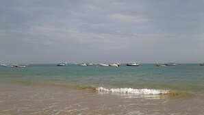Une plage où plusieurs bateaux sont amarrés dans l’eau.