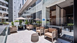 Un espacio al aire libre moderno con mobiliario de mimbre y plantas en macetas.