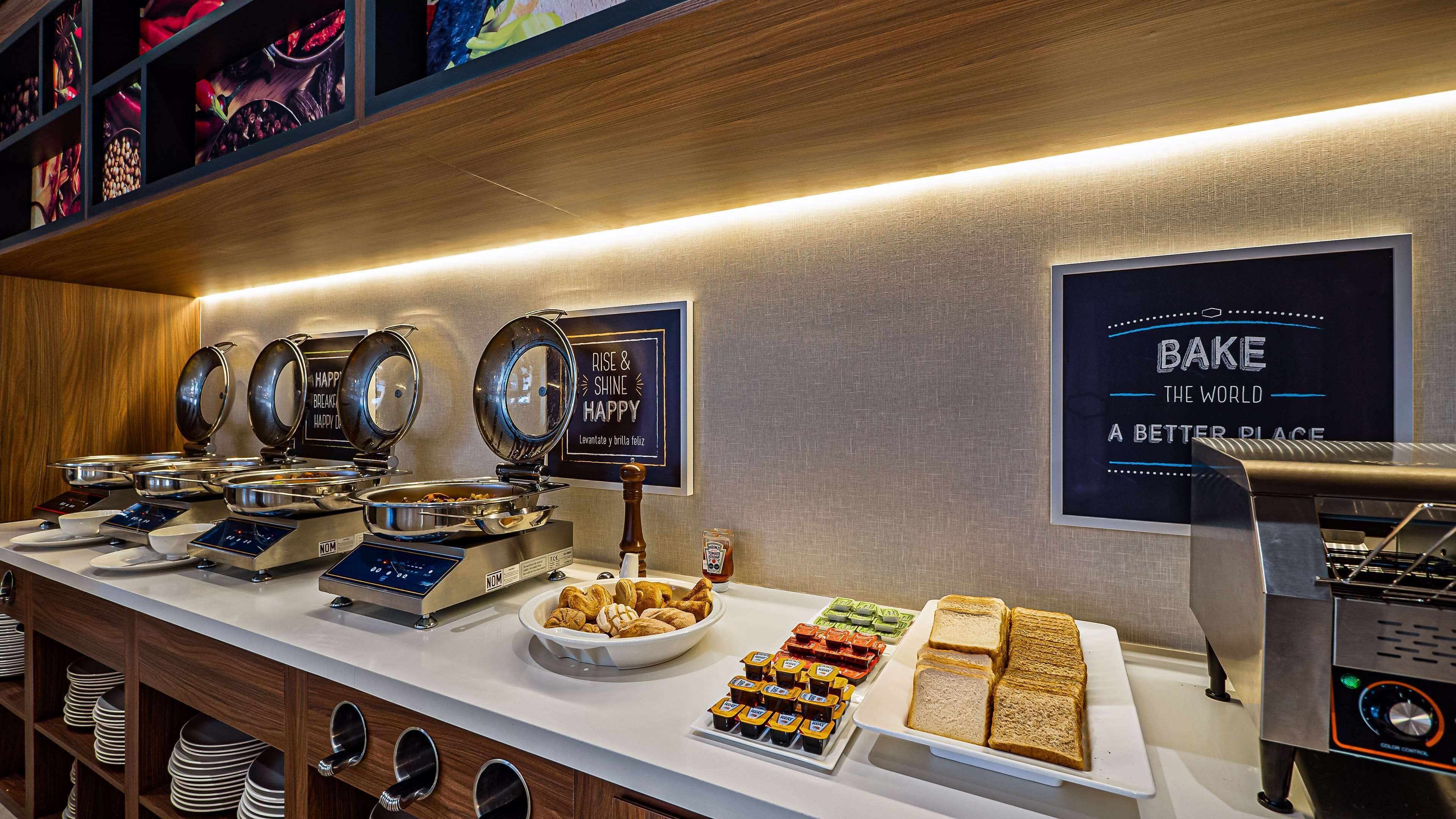 Ein reichhaltiges Buffet mit verschiedenen Speisen, darunter Brot, Gebäck und Soßen.
