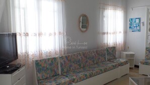 A living room with a sofa, a TV, and a small table. - Vacation home in hammamet (Hammamet)