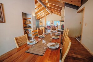 Ein Essbereich mit einem Holztisch, der für eine Mahlzeit gedeckt ist, umgeben von Korbstühlen.
