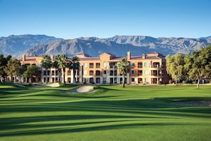 A golf course with a large building in the background.