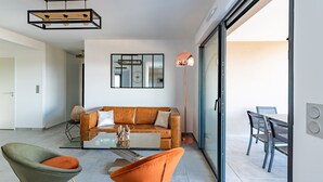 Ein modernes Wohnzimmer mit einem braunen Ledersofa, zwei Sesseln, einem Couchtisch und einer Stehlampe.