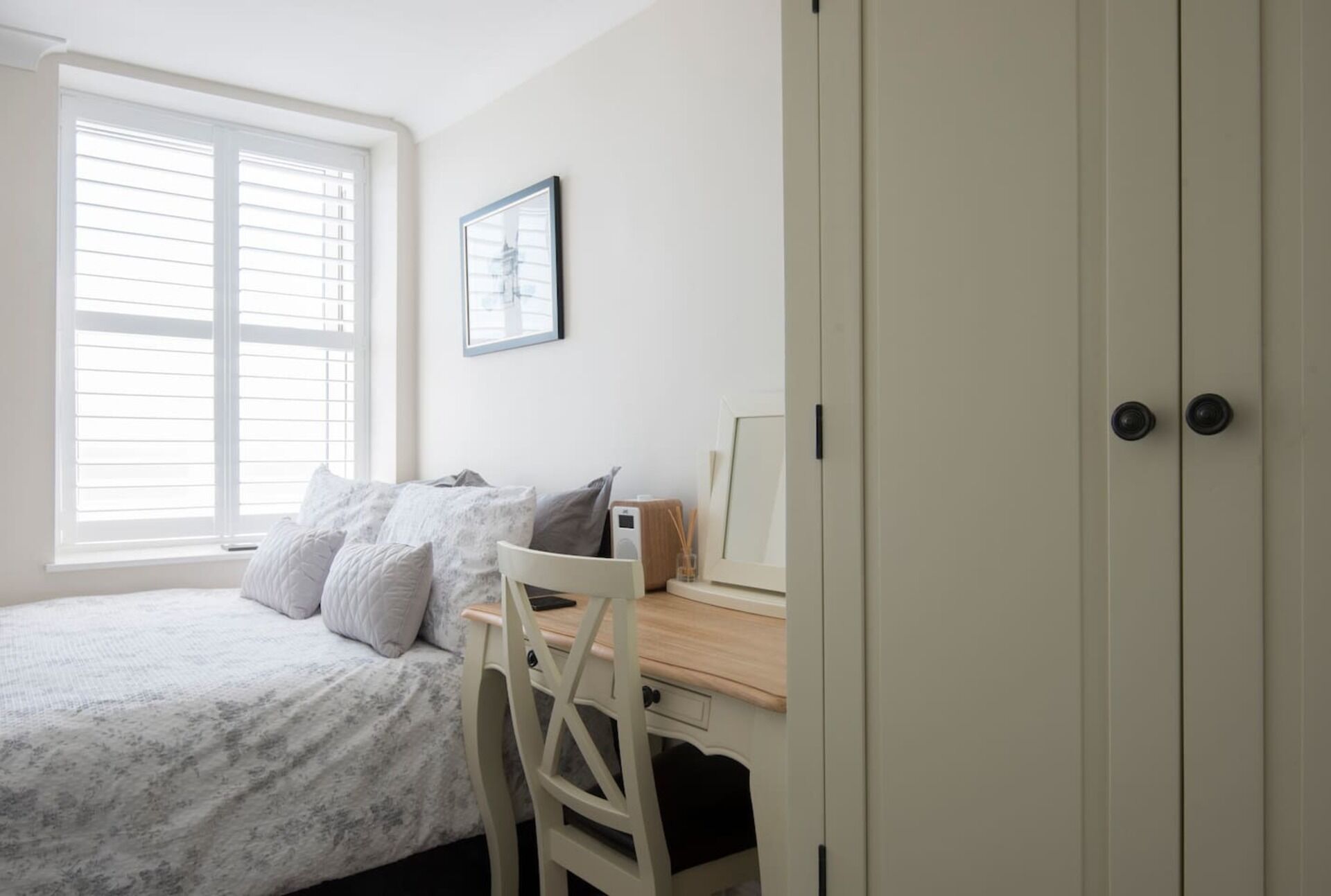 Un dormitorio con cama, escritorio y armario.