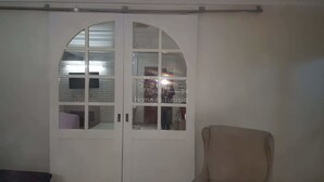 Habitació amb un armari blanc amb porta de mirall i un petit mirall.