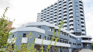 Um edifício moderno de vários andares com fachada curva e varandas.
