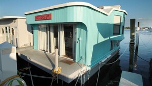 A boat with a sign reading "Captains Quarters" and a covered deck area. - Aqua Lodge Houseboat "Captain's Quarters" (Tavernier)