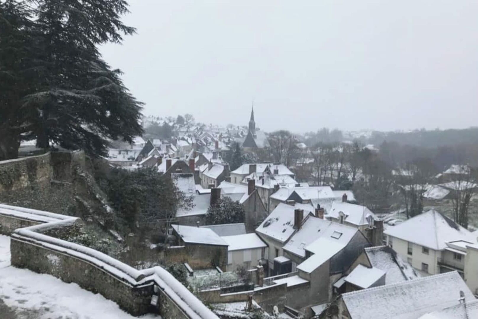Un pueblo cubierto de nieve con arquitectura tradicional, que incluye una imponente torre de iglesia.