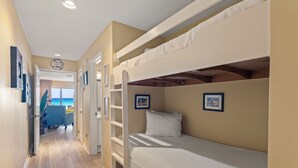 Une chambre avec des lits superposés donnant sur l’océan, vue par la porte.