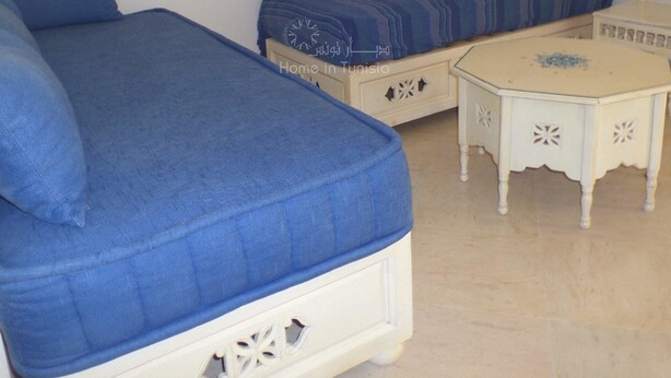 A bedroom with two blue beds, a white nightstand, and a small white table. - spacious apartment s + 2 sea view in Hammamet (Hammamet)