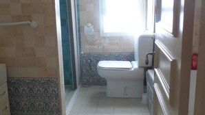 A small bathroom with a toilet, a shower area, and a window. - spacious apartment s + 2 sea view in Hammamet (Hammamet)