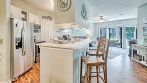 A modern kitchen with a central island, stainless steel appliances, and a view to the outdoor patio. - Luxury Lagoon View Villa Pool & Tennis Hilton Head (Hilton Head Island)