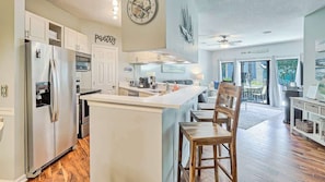 A modern kitchen with a central island, stainless steel appliances, and a view to the outdoor patio.