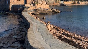 A stone pathway leading to a rustic stone building by a calm body of water, with trees and rocky terrain in the background. - Cœur de Paimpol 54 m2 (Paimpol)