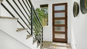 A staircase with black railings and wooden steps leading to a door with frosted glass panels.
