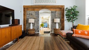 Un salon avec une cheminée en pierre, des meubles en bois, un téléviseur et une plante.
