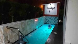 Una piscina con un muro de piedra y un letrero que dice "Villa Bagunk #".