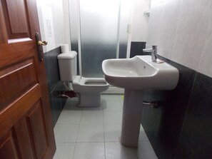 A bathroom with a toilet, a sink, and a door. - Stunning Villa in Private Compound in Nairobi, KE (Ongata Rongai)