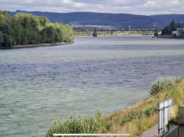 A river with a bridge in the background and a path along the riverbank. - Modernes Apartment mit Wunderschönem Rheinblick (Urmitz)
