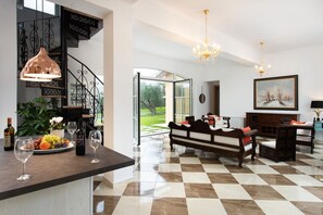A spacious living area with a checkered floor, a wooden bench, and a dining table with chairs.