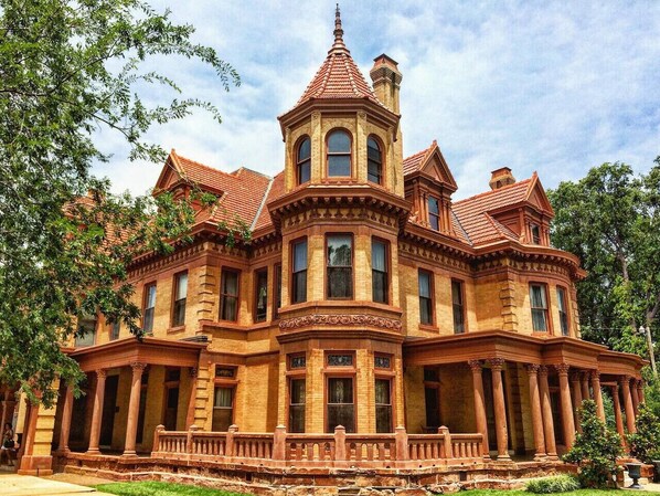 A large, historic building with a prominent tower and multiple windows.