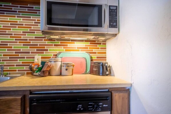 A kitchen with a microwave, a toaster, and a dishwasher.
