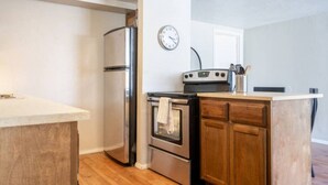 A compact kitchen with a refrigerator, oven, and microwave.