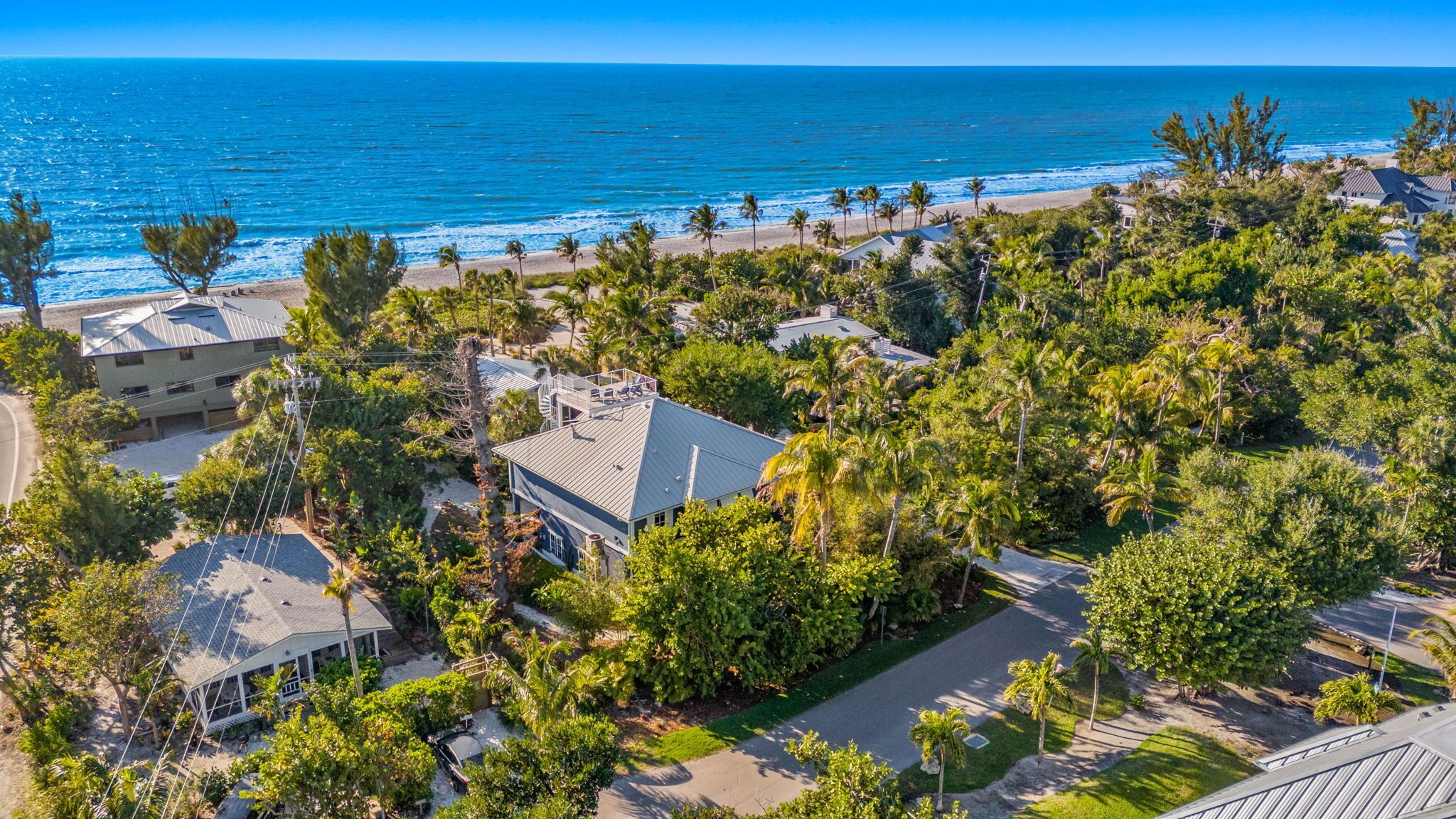 Une zone résidentielle côtière avec des maisons, une plage et des palmiers.