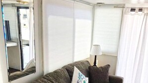 A cozy living room with a grey sofa, a mirror, and a lamp. - Aqua Lodge Houseboat "Sea Turtle" (Tavernier)