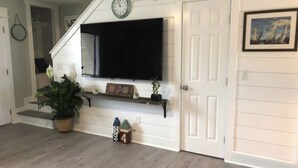 Una escalera que conduce a un rellano donde hay un televisor de pantalla plana.