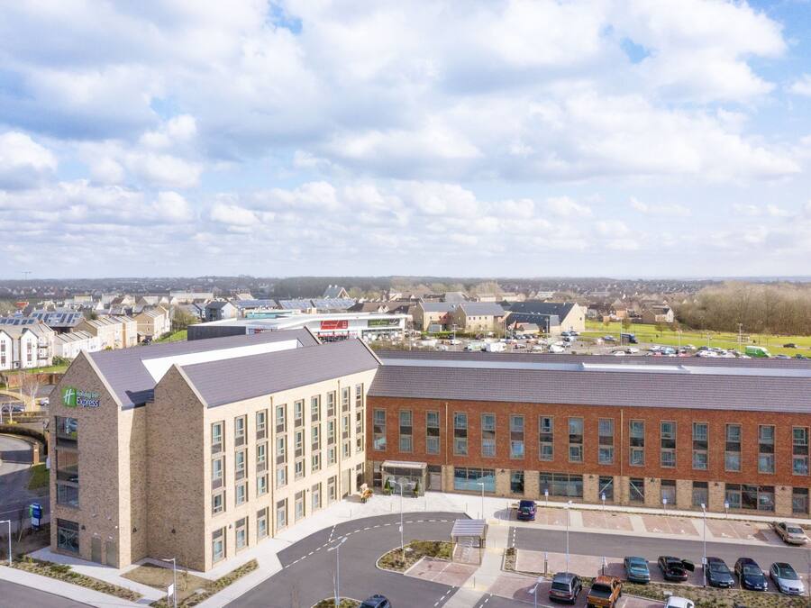A Holiday Inn Express hotel with a parking lot and a view of the surrounding area.
