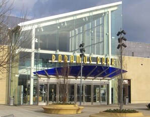 A modern building with a glass facade and a blue awning.
