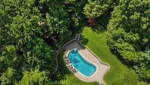 Ein Luftbild zeigt einen Pool, umgeben von üppiger Vegetation.