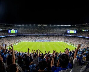 Un stade rempli de spectateurs, un terrain de football et le nom du stade : « METLIFE STADIUM ».
