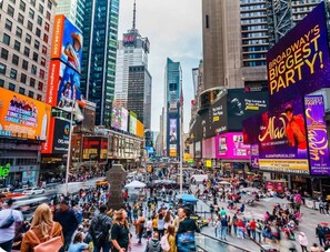 A busy urban street with tall buildings and large billboards.