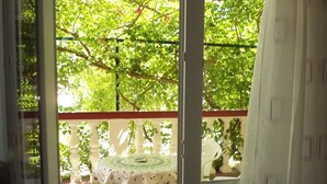 A room with a sliding glass door leading to an outdoor area with a table and chairs, a small plant, and a tiled floor. - Apartment in Lopar with Terrace, Air condition, WIFI, Washing machine (4229-3) (Lopar)