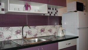 A kitchen with purple cabinets, a stainless steel sink, a microwave, and a kettle. - Apartment in Lopar with Terrace, Air condition, WIFI, Washing machine (4229-3) (Lopar)