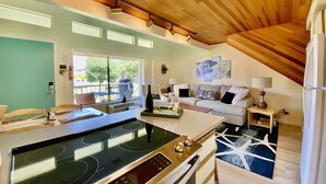 A modern kitchen with an induction cooktop, a dining area with a table and chairs, a sofa, and a ceiling fan. - Well Appointed Oasis in the Sun! ☀️⚓️🏖 Pool, Beach, Boat Launch, Gorge, Wineries (Quincy)