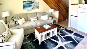 A cozy living room with a sofa, coffee table, and a nautical-themed wall decoration. - Well Appointed Oasis in the Sun! ☀️⚓️🏖 Pool, Beach, Boat Launch, Gorge, Wineries (Quincy)