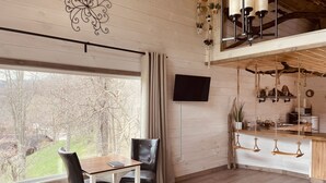 A modern kitchen with a wooden countertop, hanging lights, and a TV mounted on the wall. - The "Hang-over"  Winery Treehouse (Weston)