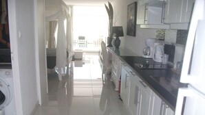 A bright kitchen with white cabinets, a black countertop, and a view to the outside. - ♥Charming studio ♥♥ near Orient Bay beach (Saint Martin)