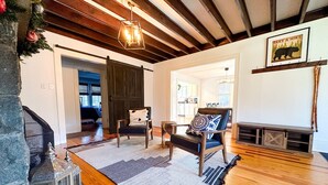 A cozy living room with a fireplace, wooden floors, and a stone accent wall.