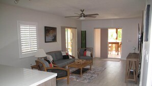 A spacious living area with a sofa, chairs, a coffee table, and a dining area with a table and chairs. - Oceanside Key Largo Beauty w/Dock for 40' Boat (Key Largo)