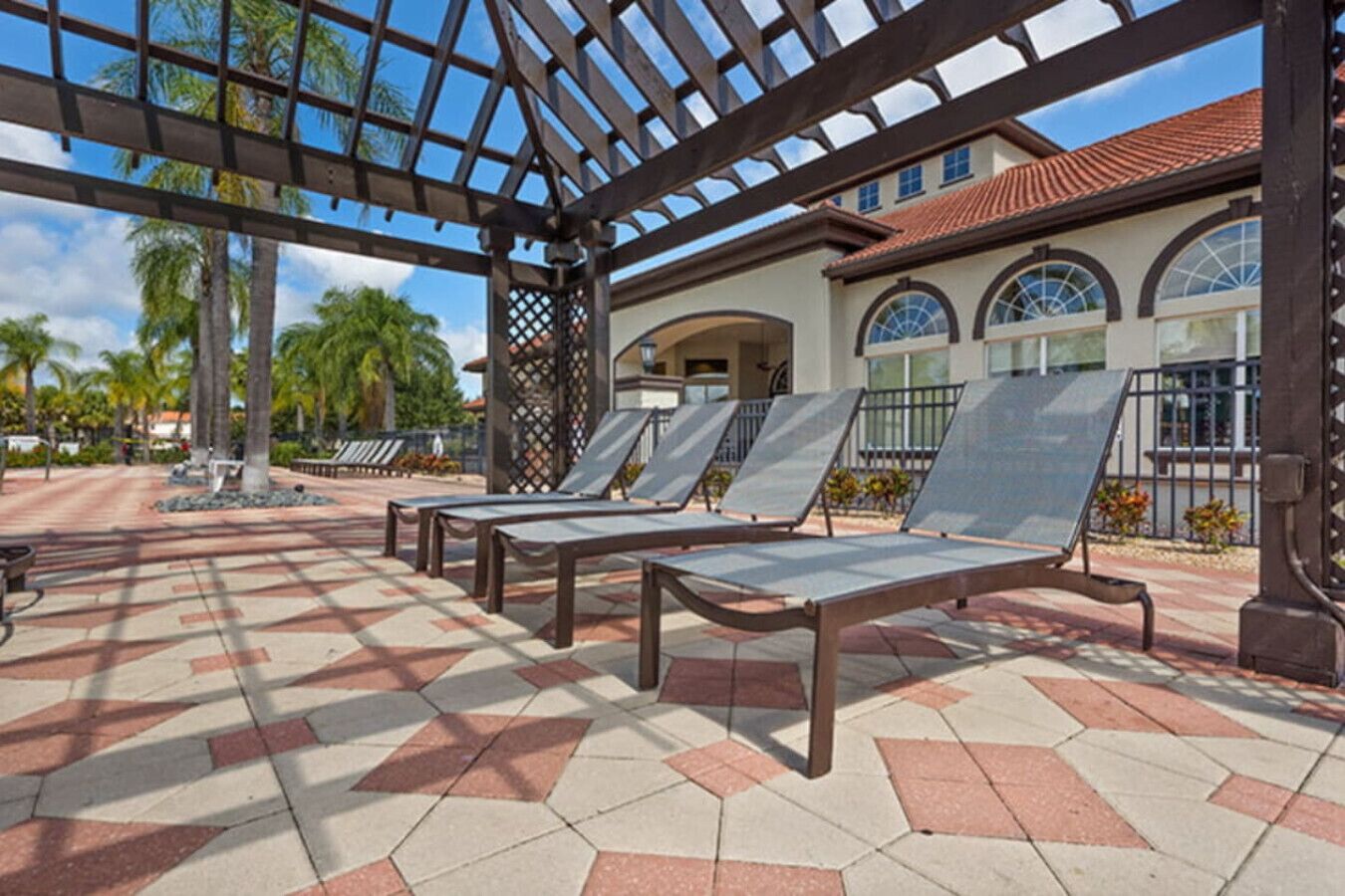 A covered outdoor area with sun loungers and a tiled floor.